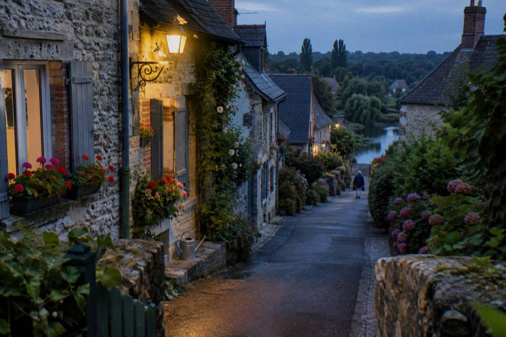Flower-lined lane in Giverny village with cottage gardens in soft evening light